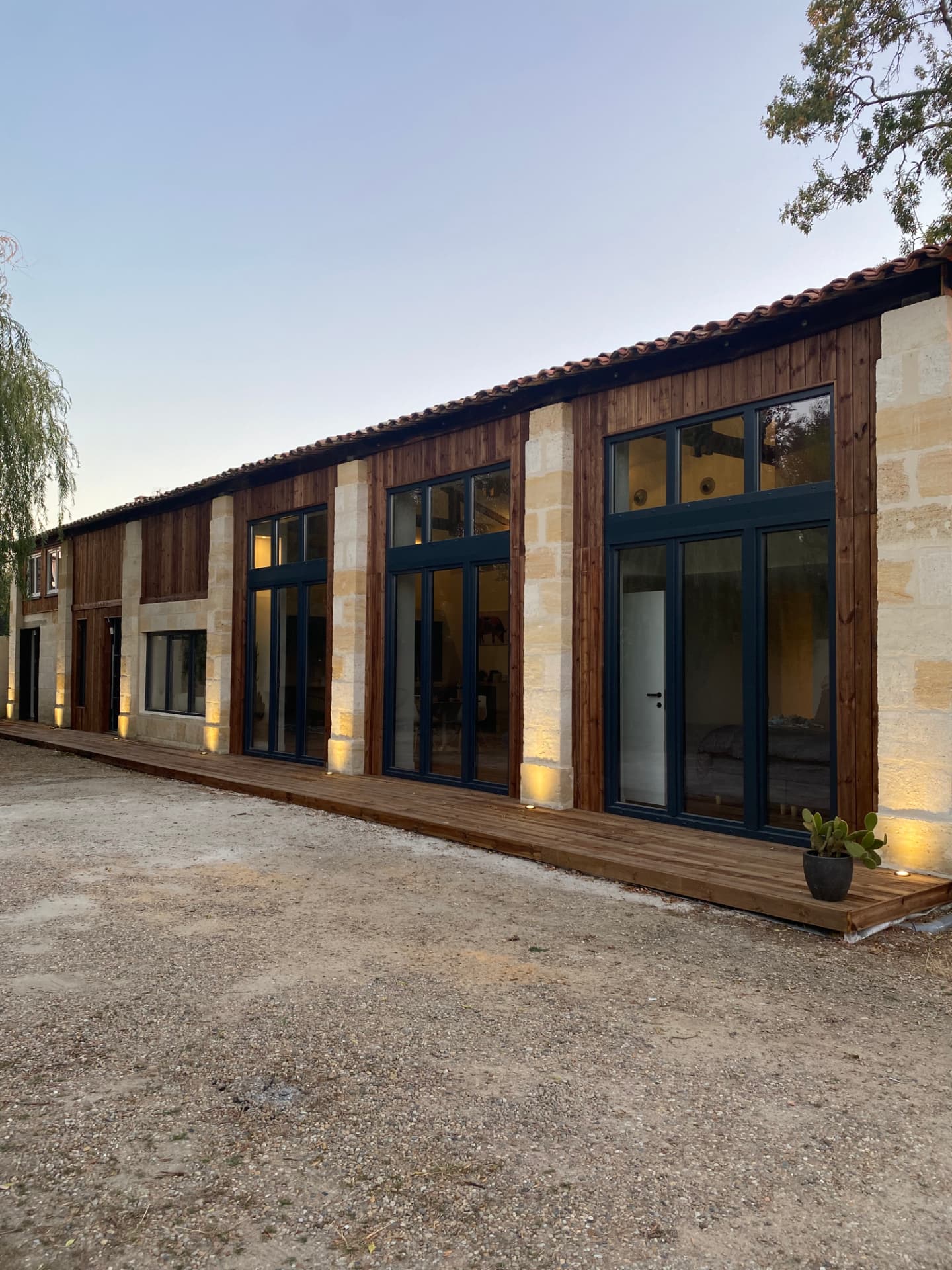 Façade réhabilitée avec pierre, bardage bois et grandes menuiseries